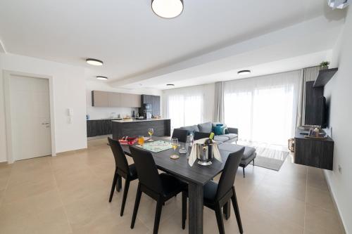 a dining room and living room with a table and chairs at Luxury Apartment Valley Views C5 in Xagħra