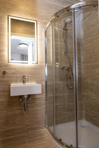 a bathroom with a glass shower and a sink at Luxury Apartment Valley Views C5 in Xagħra