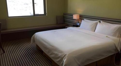 Кровать или кровати в номере Xiamenair Maple Hotel (Xiamen SM City Plaza)