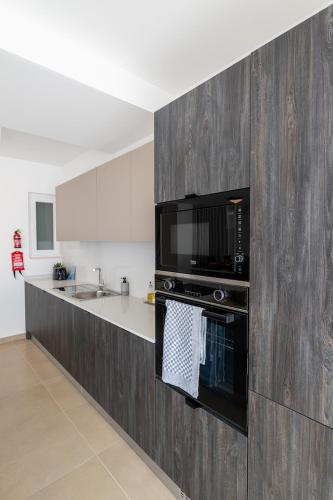 a kitchen with a black microwave and a counter at Luxury Apartment Valley Views C5 in Xagħra