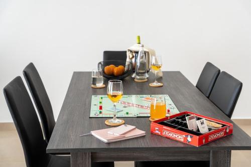 a wooden table with wine glasses and a box on it at Luxury Apartment Valley Views C5 in Xagħra