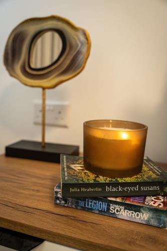 a candle sitting on top of a table with books at Luxury Apartment Valley Views C5 in Xagħra