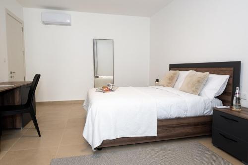 a bedroom with a large bed with a desk and a chair at Luxury Apartment Valley Views C5 in Xagħra
