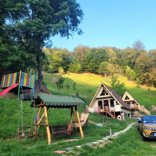 a group of cottages with a car parked in front at Cabanele lui Sem in Oeștii Ungureni