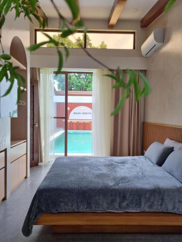 a bedroom with a bed and a large window at Balay Vicente in Tarlac