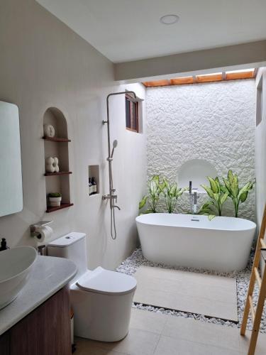 a bathroom with a tub and a toilet and a sink at Balay Vicente in Tarlac