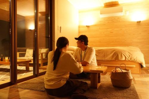 een man en vrouw aan een tafel in een kamer bij STELLA SPORTS - Vacation STAY 46140v in Nishimera