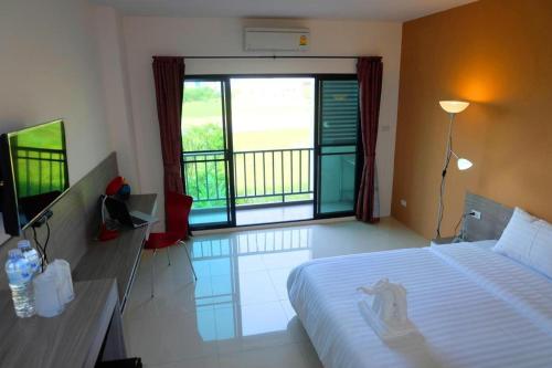 a bedroom with a bed and a large window at The Pride in Nakhon Pathom
