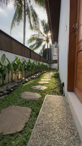 a walkway with palm trees on the side of a building at Bukit Langit Campventure in Glagah