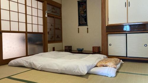 a bedroom with a white bed in a room with windows at Guest House Yasuragi Kamigoto - Vacation STAY 45616v in Shinkamigoto