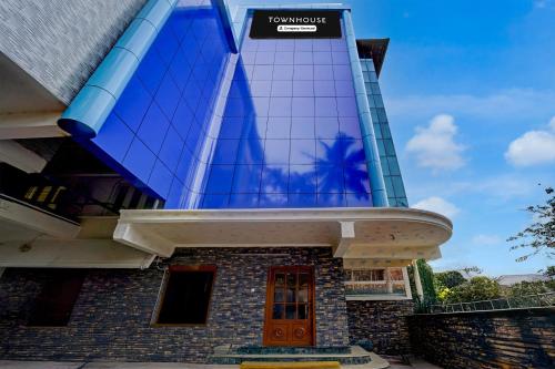 a building with a sign on the side of it at Super Townhouse Green Field Stadium Karyavattom in Kazhakuttam