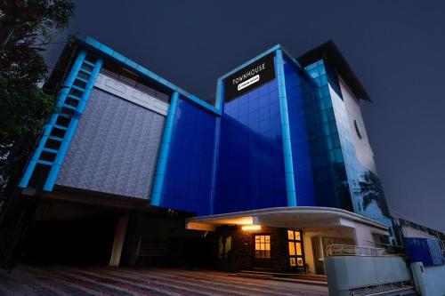 a blue building with a sign on it at night at Super Townhouse Green Field Stadium Karyavattom in Kazhakuttam