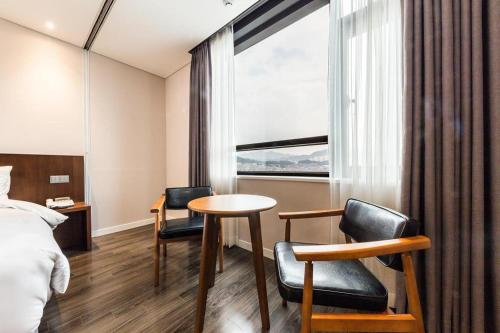 a hotel room with a bed and a table and chairs at CS Premier Hotel in Seoul