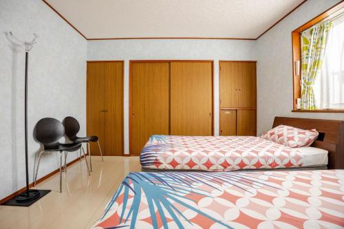 a bedroom with two beds and a chair in it at Twilight Villa Onjuku - Vacation STAY 52776v in Iwada