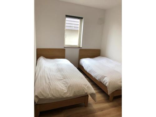 美瑛町にあるMinshuku Cress - Vacation STAY 48547vの窓のある小さな部屋にベッドが2つある