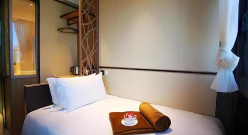 a hotel room with a bed with a towel on it at Ehotel in Hong Kong