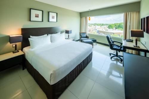 a hotel room with a bed and a desk and chairs at Crowne Plaza Villahermosa by IHG in Villahermosa