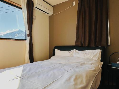 ein Bett in einem Zimmer mit Fenster in der Unterkunft Villa Sanmado Panorama BBQ Bonfire Fuji view Annov - Vacation STAY 59398v in Fujikawaguchiko