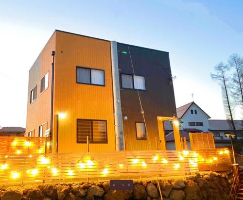 ein gelbes Gebäude mit Lichtern davor in der Unterkunft Villa Sanmado Panorama BBQ Bonfire Fuji view Annov - Vacation STAY 59398v in Fujikawaguchiko