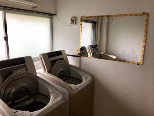 eine Waschküche mit 2 Waschmaschinen und einem Spiegel in der Unterkunft Oasis Wadaura - Vacation STAY 67404v in Kamogawa