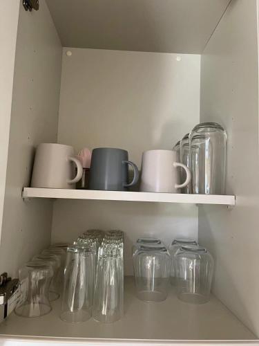 a row of glass jars and cups on a shelf at Maisonette Hanazono - Vacation STAY 63319v in Kemigawa-machi