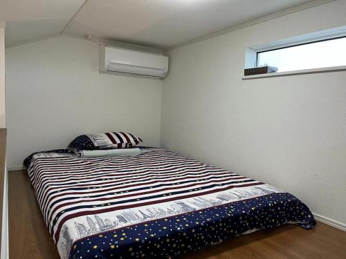 a small bedroom with a bed in the corner at Maisonette Hanazono - Vacation STAY 63319v in Kemigawa-machi