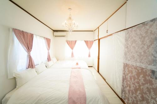 a bedroom with a bed with a pink tie on it at Yokkaichi - House - Vacation STAY 14171 in Yokkaichi