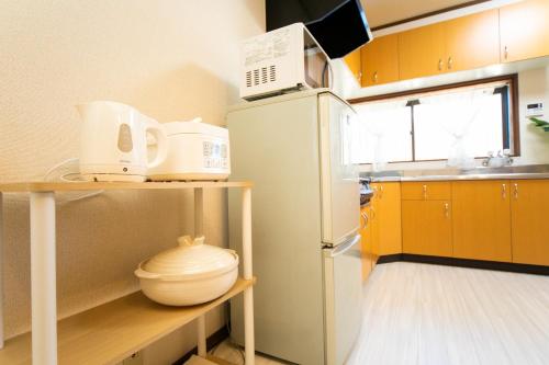 a kitchen with yellow cabinets and a white refrigerator at Yokkaichi - House - Vacation STAY 14171 in Yokkaichi