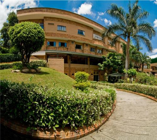 a building with a tree in front of it at Hotel Palmera Real in Bucaramanga