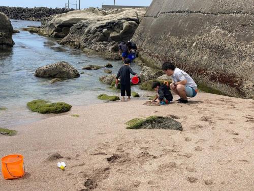 a group of children playing in the sand on the beach at Oasis Wadaura - Vacation STAY 89769v in Kamogawa