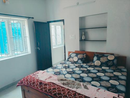 a bedroom with a bed in a room with two windows at SHALOM HOME STAY valparai in Vālpārai