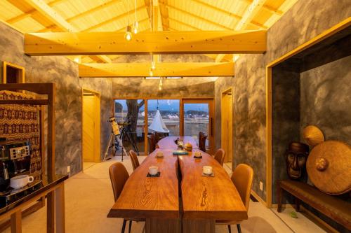 ein Esszimmer mit einem Holztisch und Stühlen in der Unterkunft Mt, FUJI SATOYAMA VACATION - Vacation STAY 85278v in Kami-ide