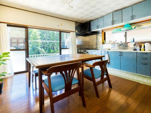 a kitchen with a wooden table and blue cabinets at Goenza OYADO - Vacation STAY 86977v in Takinohai