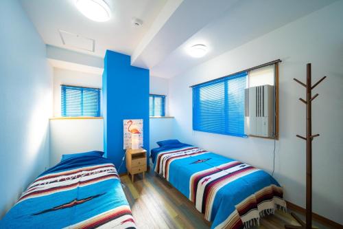 2 Betten in einem Schlafzimmer mit blauen Wänden und Fenstern in der Unterkunft Heritage 21 - Vacation STAY 14227 in Beppu