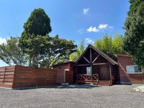 a wooden barn with a fence and a garage at Otomie Log House - Vacation STAY 69826v in Kimitsu