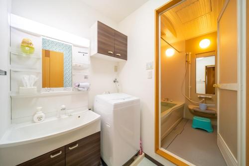 ein weißes Badezimmer mit Waschbecken und Badewanne in der Unterkunft Heritage 21 - Vacation STAY 14227 in Beppu