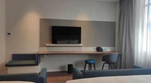 a room with a counter with a television and chairs at Holiday Inn Express Jingdezhen Ancient Town By IHG in Jingdezhen