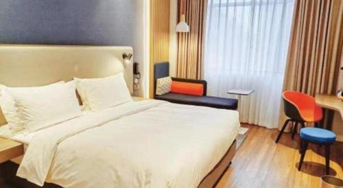 a hotel room with a large bed and a desk at Holiday Inn Express Jingdezhen Ancient Town By IHG in Jingdezhen