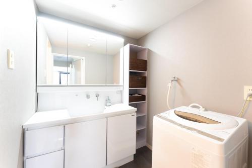 a white bathroom with a sink and a mirror at VIVI Atami Shizenkyo Room 3001 - Vacation STAY 14277 in Atami