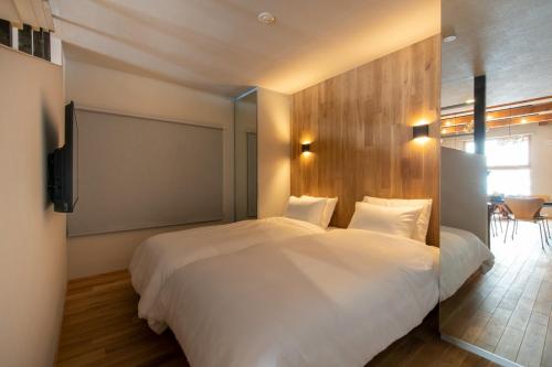 a bedroom with a large white bed and a television at Abuta-gun - House - Vacation STAY 14526 in Kutchan