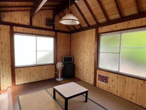 a room with wooden walls and windows and a table at Yotsubaso Bungalow Village - Vacation STAY 85282v in Moriya
