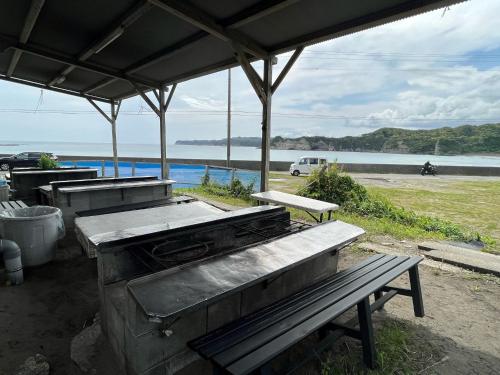 an outdoor grill and a bench under a pavilion at Yotsubaso Bungalow Village - Vacation STAY 85281v in Moriya