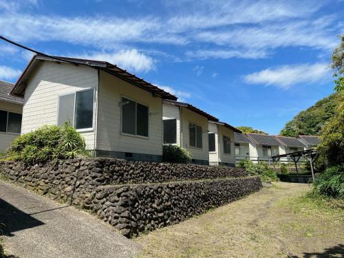 a house with a stone wall in front of it at Yotsubaso Bungalow Village - Vacation STAY 85281v in Moriya