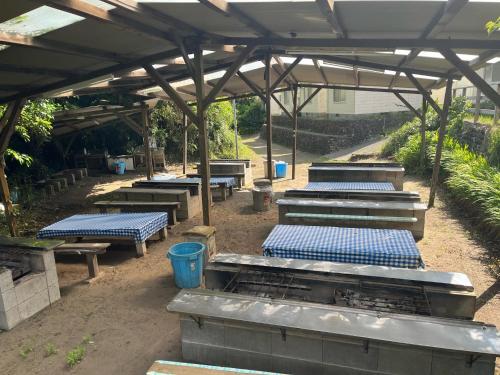 a group of picnic tables under a metal roof at Yotsubaso Bungalow Village - Vacation STAY 85281v in Moriya