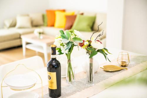 a bottle of wine and vases with flowers on a table at ナガシマリバーサイドリゾート - Vacation STAY 94113v in Kuwana