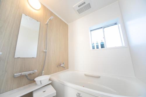 a bathroom with a white tub and a window at ナガシマリバーサイドリゾート - Vacation STAY 94113v in Kuwana
