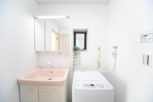 a white bathroom with a sink and a mirror at ナガシマリバーサイドリゾート - Vacation STAY 94113v in Kuwana