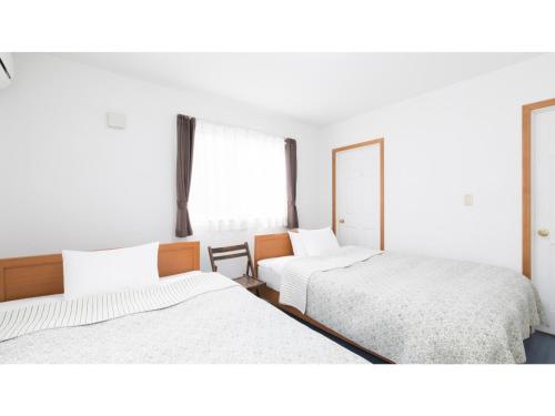 a bedroom with two beds and a mirror at TEA TREES - Vacation STAY 86519v in Tateyama