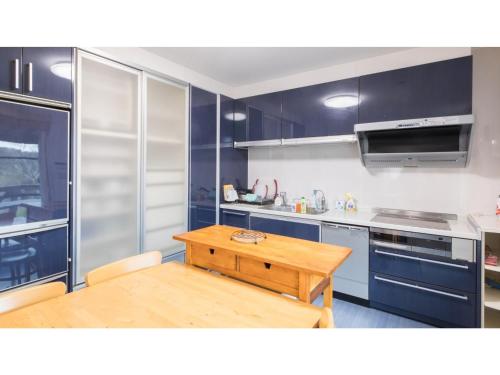 a kitchen with blue cabinets and a wooden table at TEA TREES - Vacation STAY 86519v in Tateyama