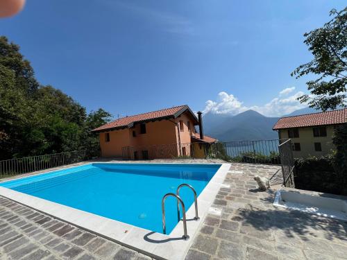 a villa with a swimming pool and mountains in the background at Rododendro House Relax in Germasino